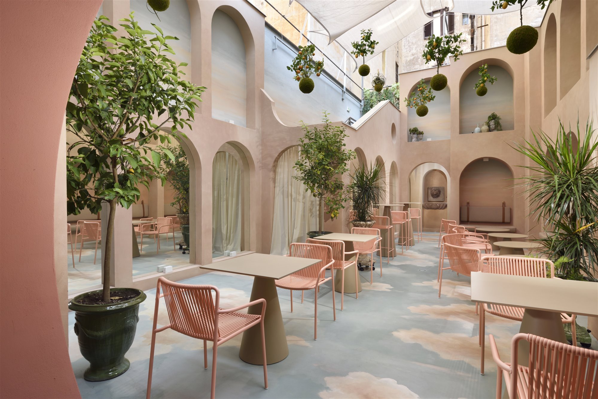 Patio con arcos de color rosa del hotel Leon Place en Roma 2