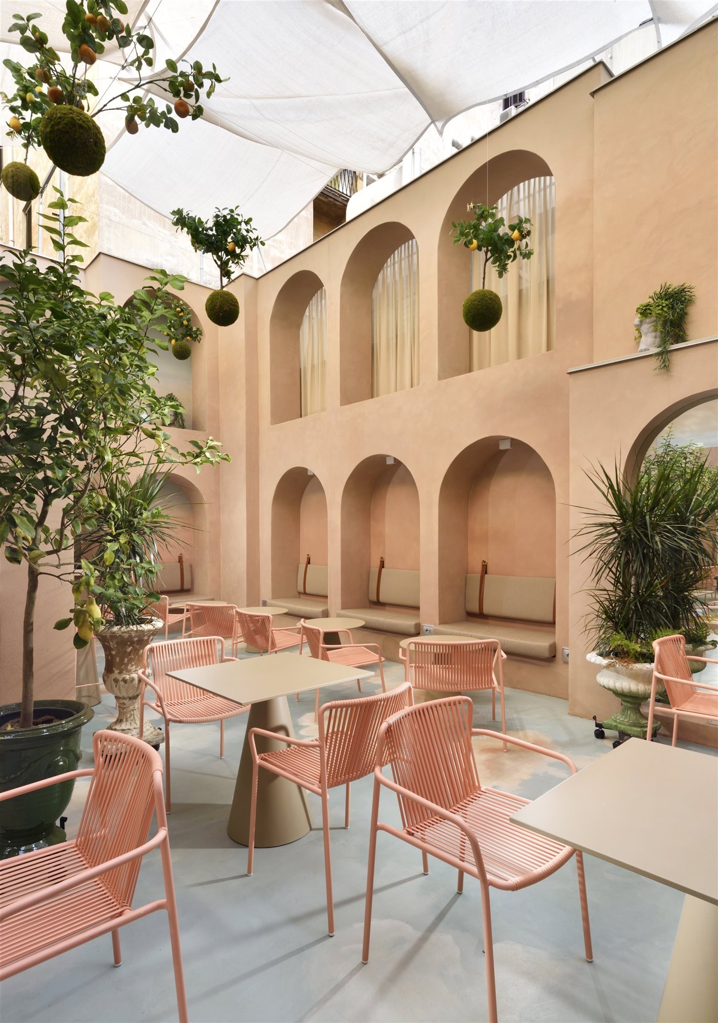 Patio con arcos de color rosa del hotel Leon Place en Roma 3