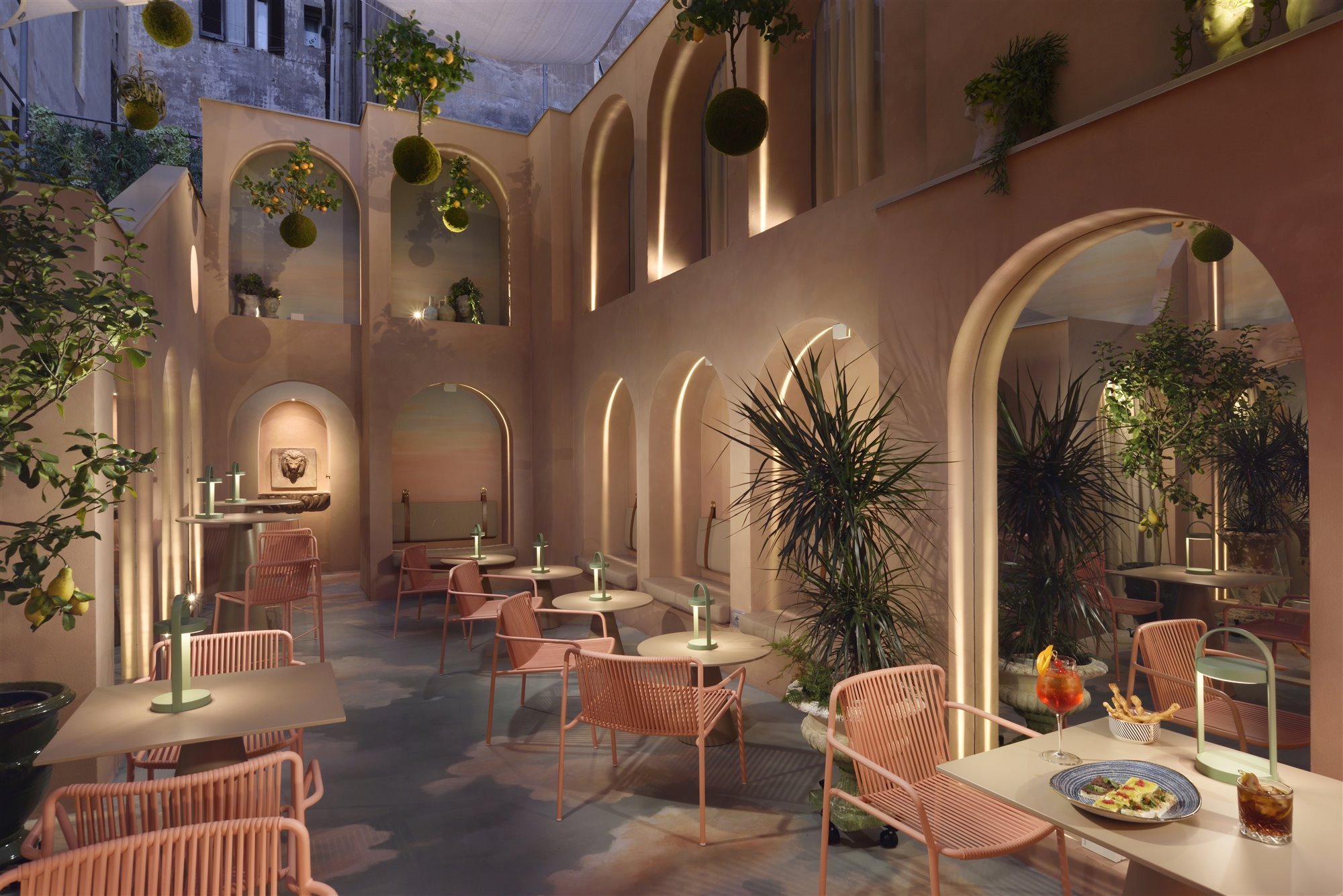 Patio con arcos de color rosa del hotel Leon Place en Roma 7