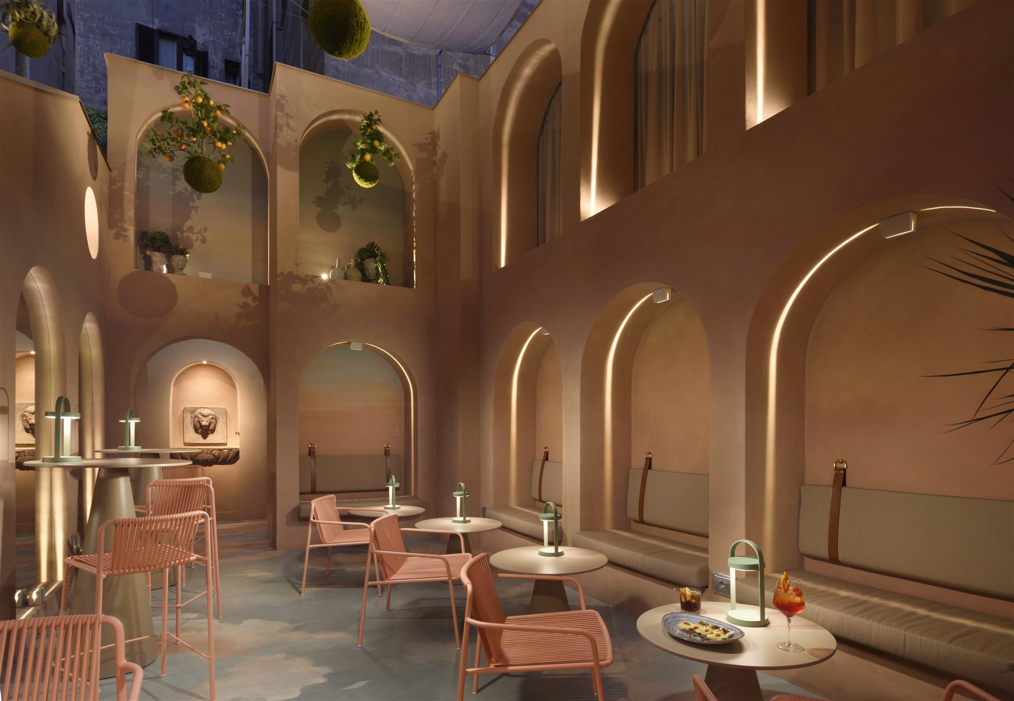 Patio con arcos de color rosa del hotel Leon Place en Roma 8