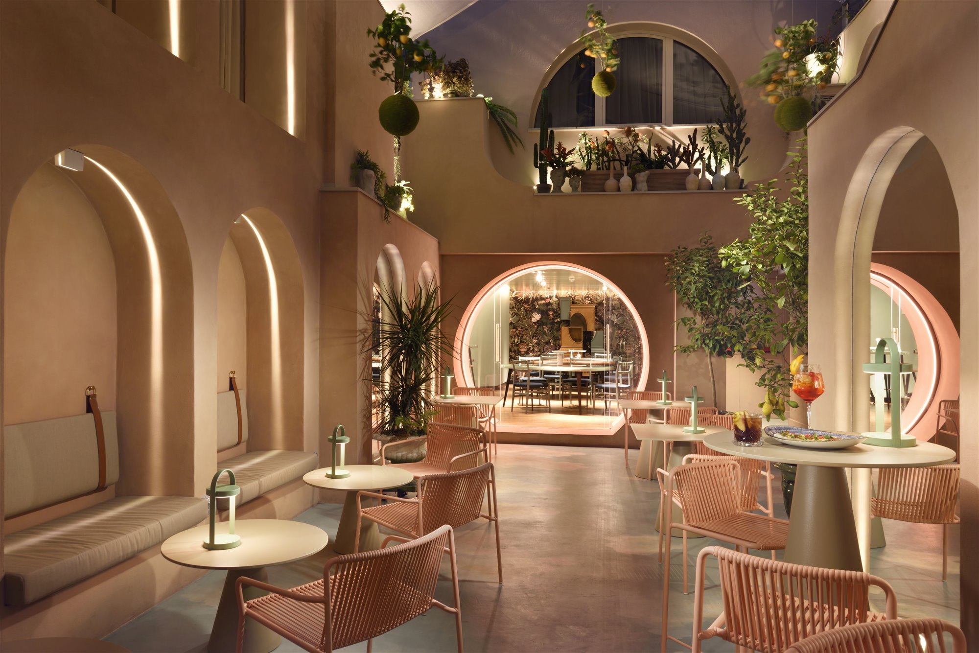Patio con arcos de color rosa del hotel Leon Place en Roma 9
