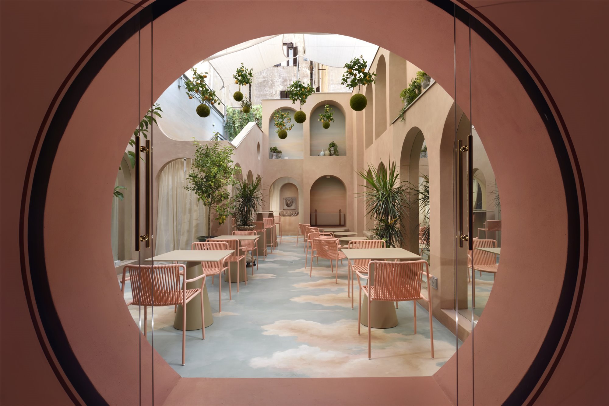 Patio con arcos de color rosa del hotel Leon Place en Roma