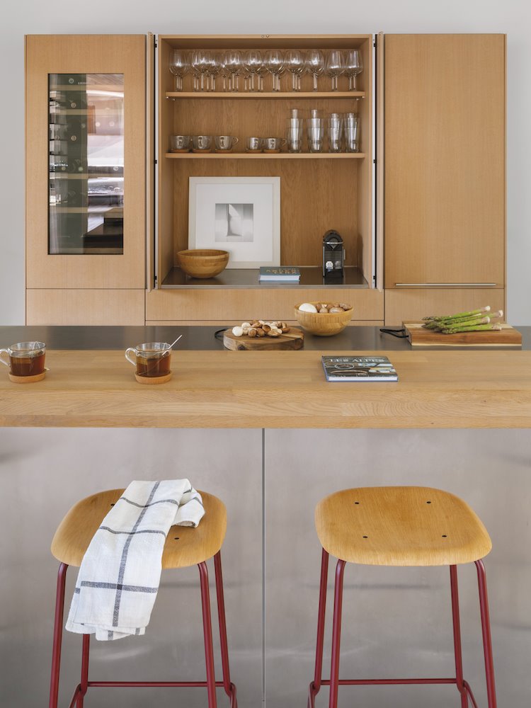 Cocina con taburetes industriales de una casa en Barcelona diseñada por Espacio en Blanco