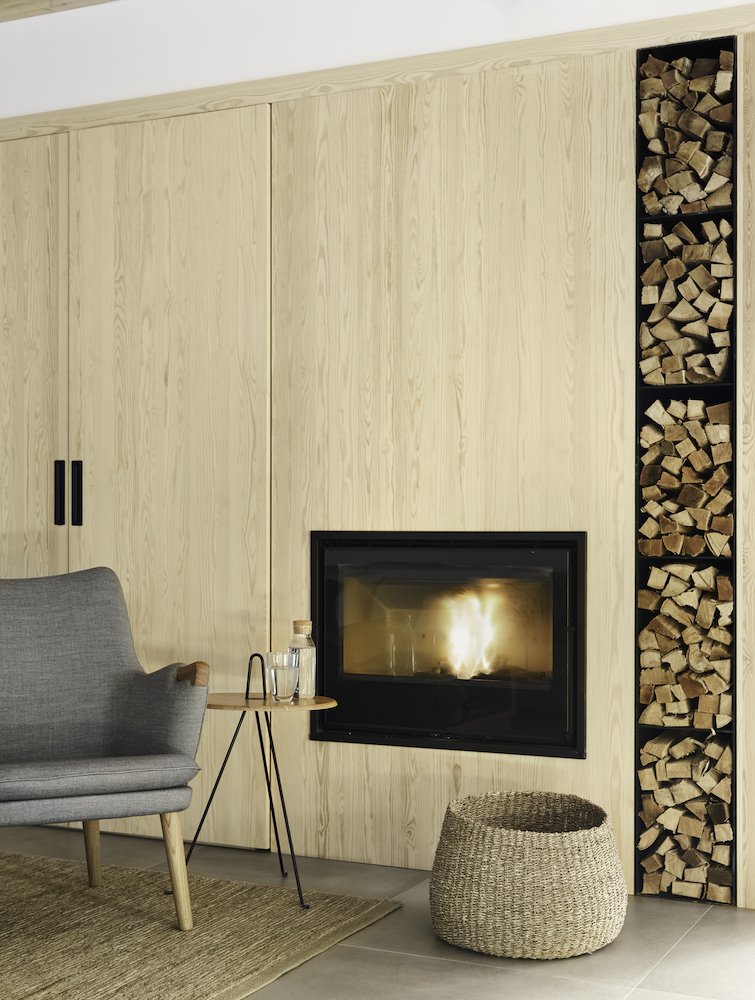 Salon con chimenea y troncos de madera de estilo rustico