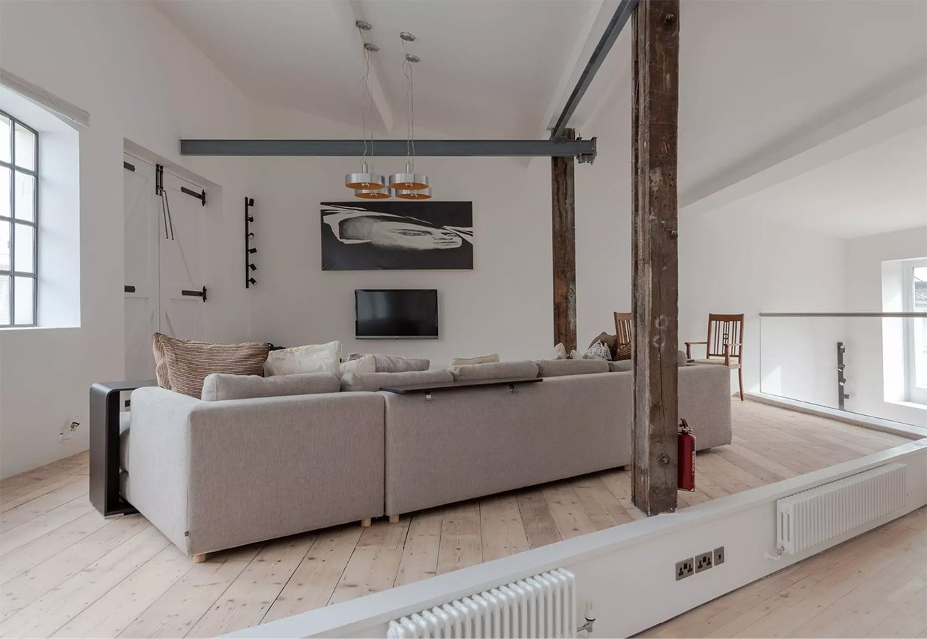 Antigua fabrica convertida en un loft moderno en londres salon con vigas de madera