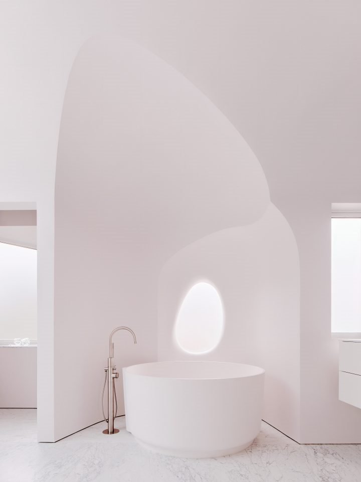 Casa en california con paredes organicas de color blanco baño