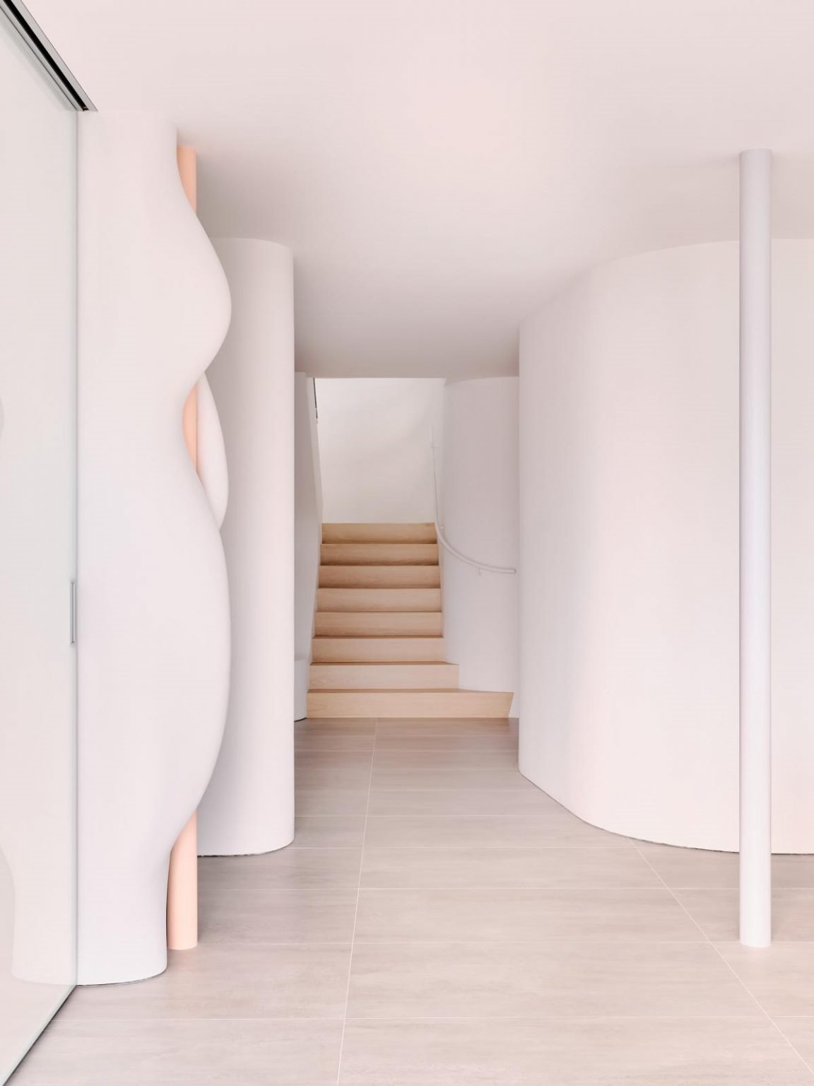 Casa en california con paredes organicas de color blanco entrada