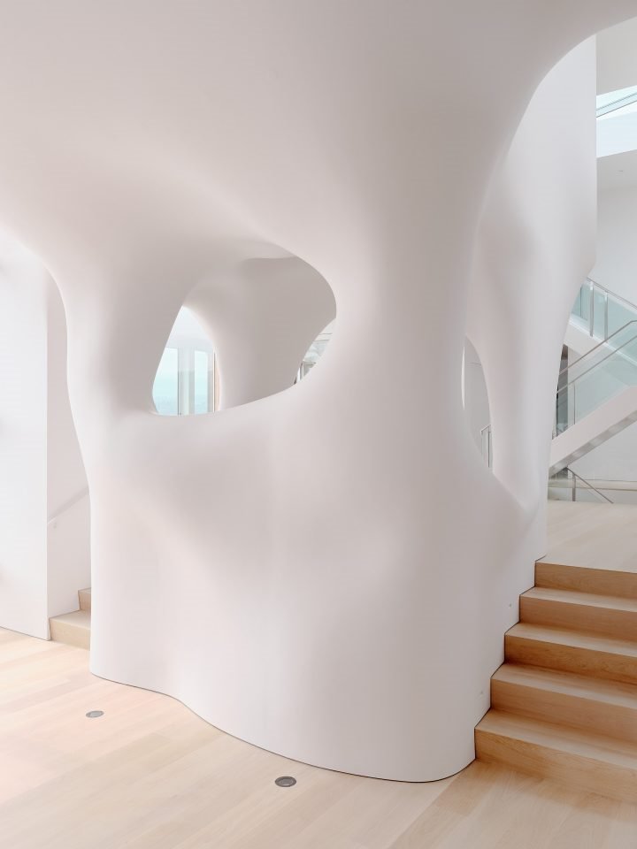 Casa en california con paredes organicas de color blanco escalera