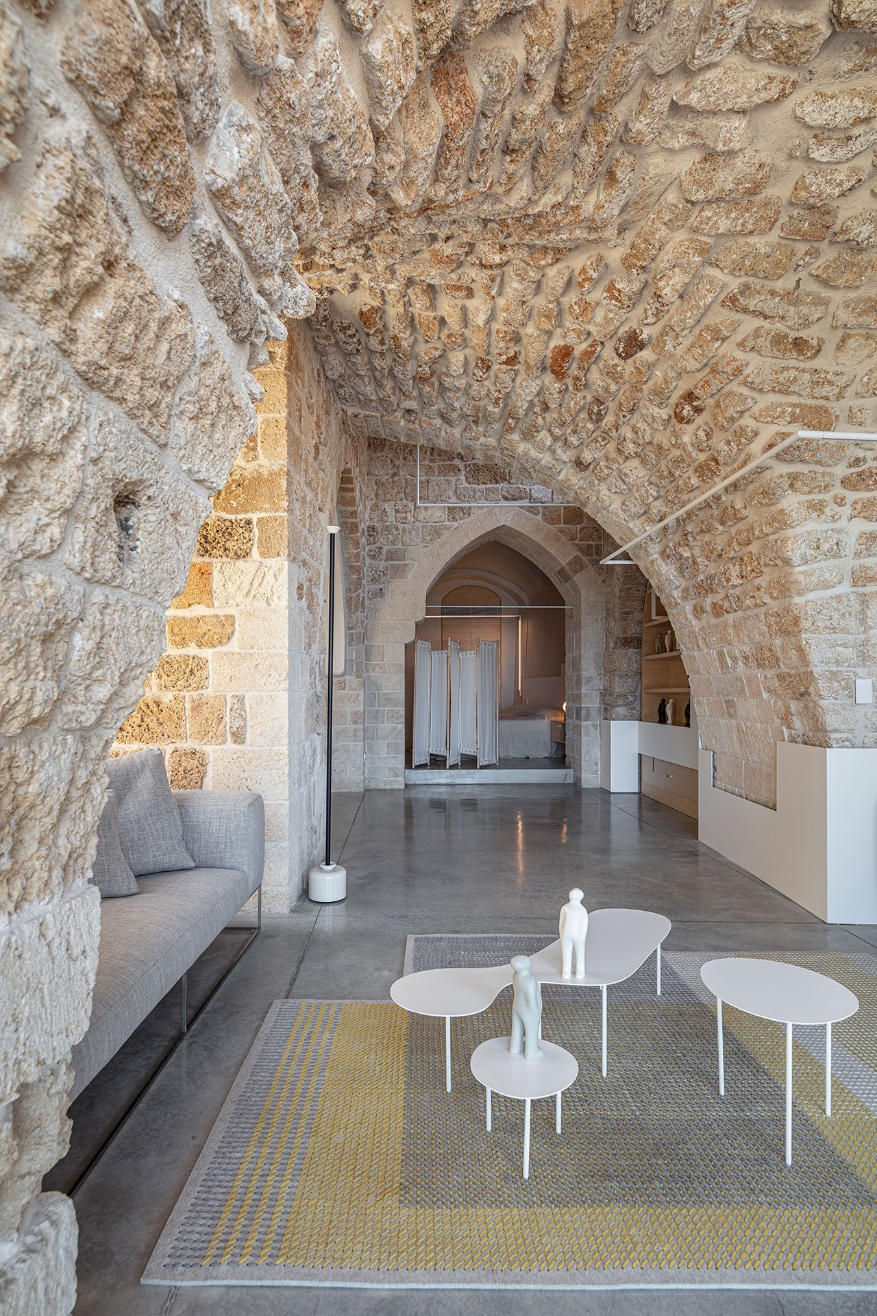 Casa moderna de piedra y ladrillo reformada en Tel Aviv por el arquitecto Pitsou Kedem salon con mesillas blancas