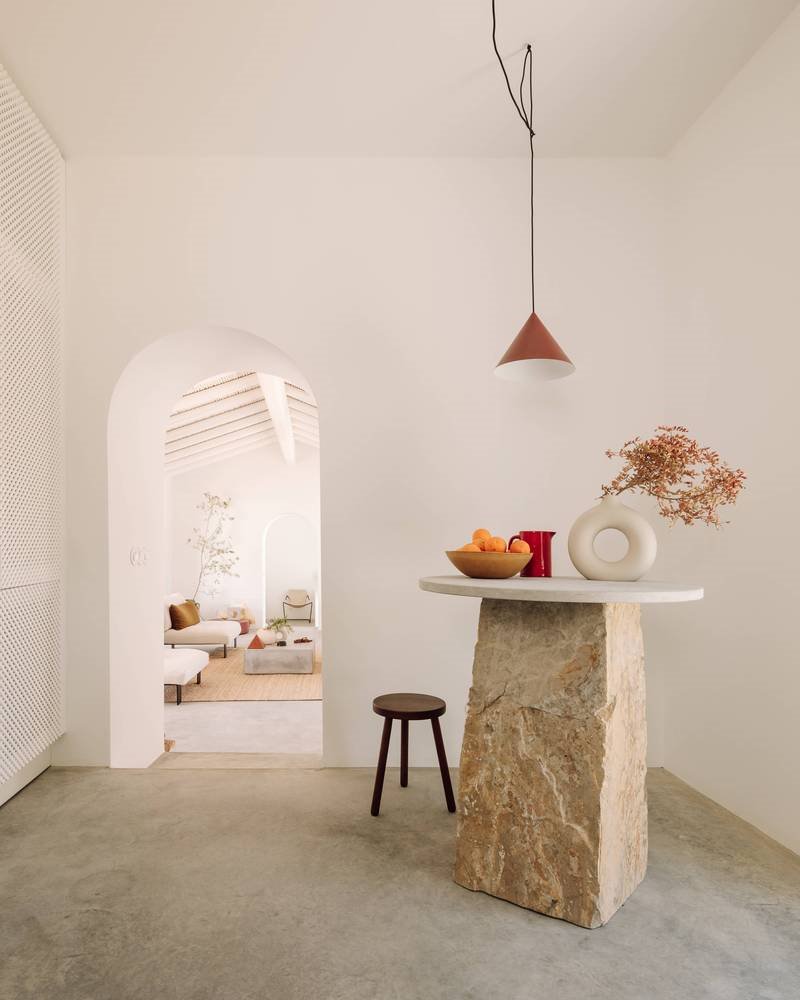 Casa de vacaciones en el algarve en Portugal con fachada e interiores de color blanco rincon con mesa de piedra