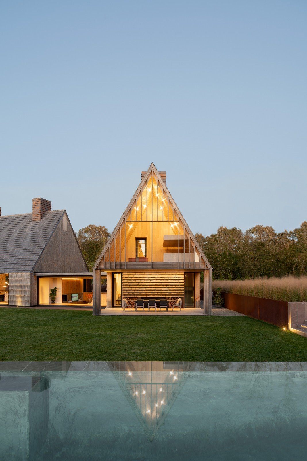 Casa moderna en el campo con fachada de paja porche abierto con un lago