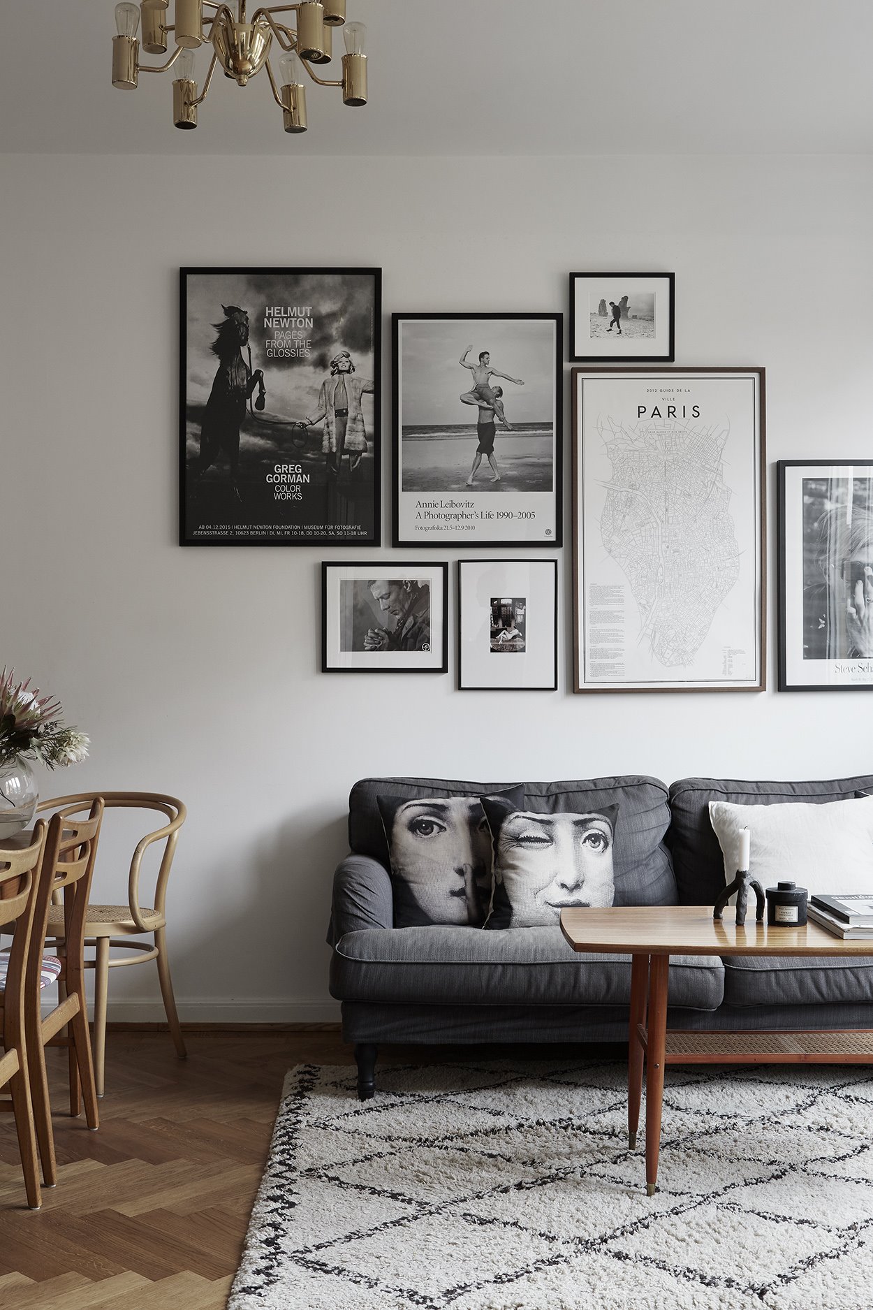 Salon de un piso con cuadros en la pared y sofa gris. Algo de arte
