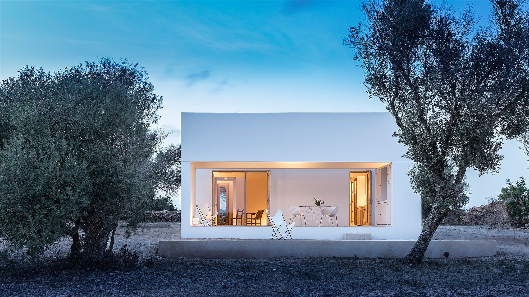 Casa blanca en Formentera del arquitecto Maria Castello porche encendido al atardecer