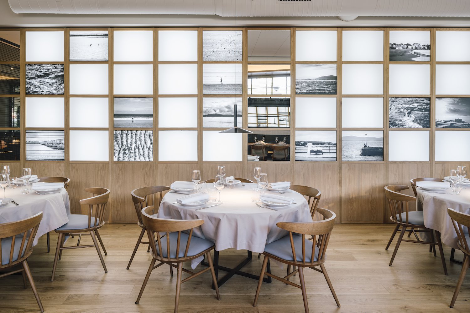 Restaurante La Maruca del estudio de arquitectura Zooco espacio con fotos y mesas redondas