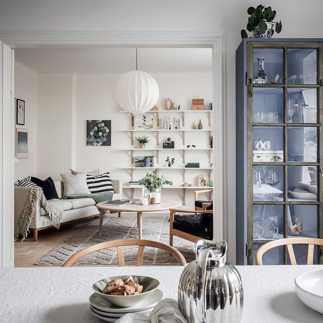 Salon comedor con estanterias y sofa gris. Un piso amueblado