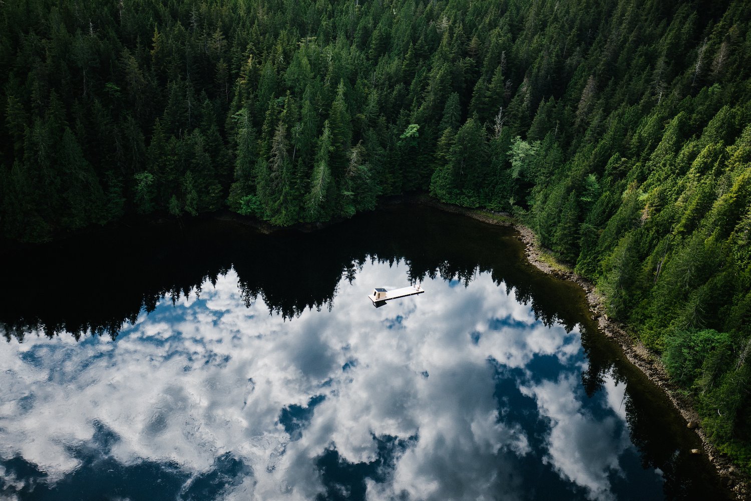 Cabaña moderna con Sauna de madera flotando en mitad de un lago en un bosque