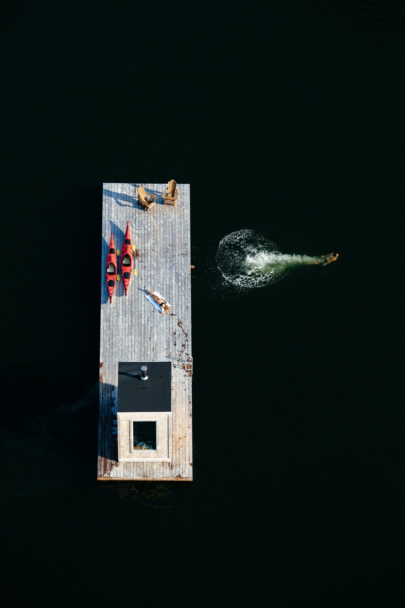Cabaña moderna con Sauna de madera flotando en mitad de un lago vista aerea
