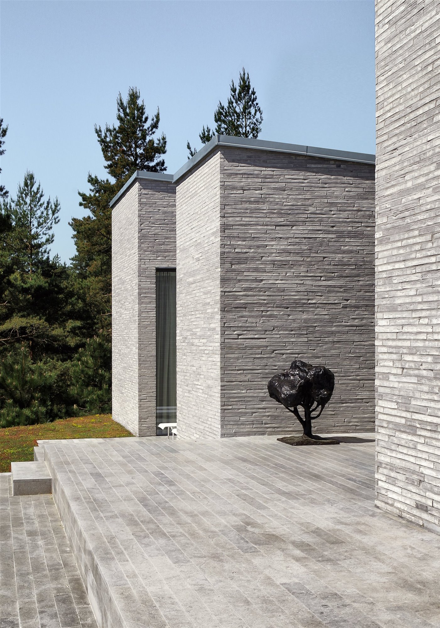 Casa moderna con fachada de piedra en mitad del bosque entrada