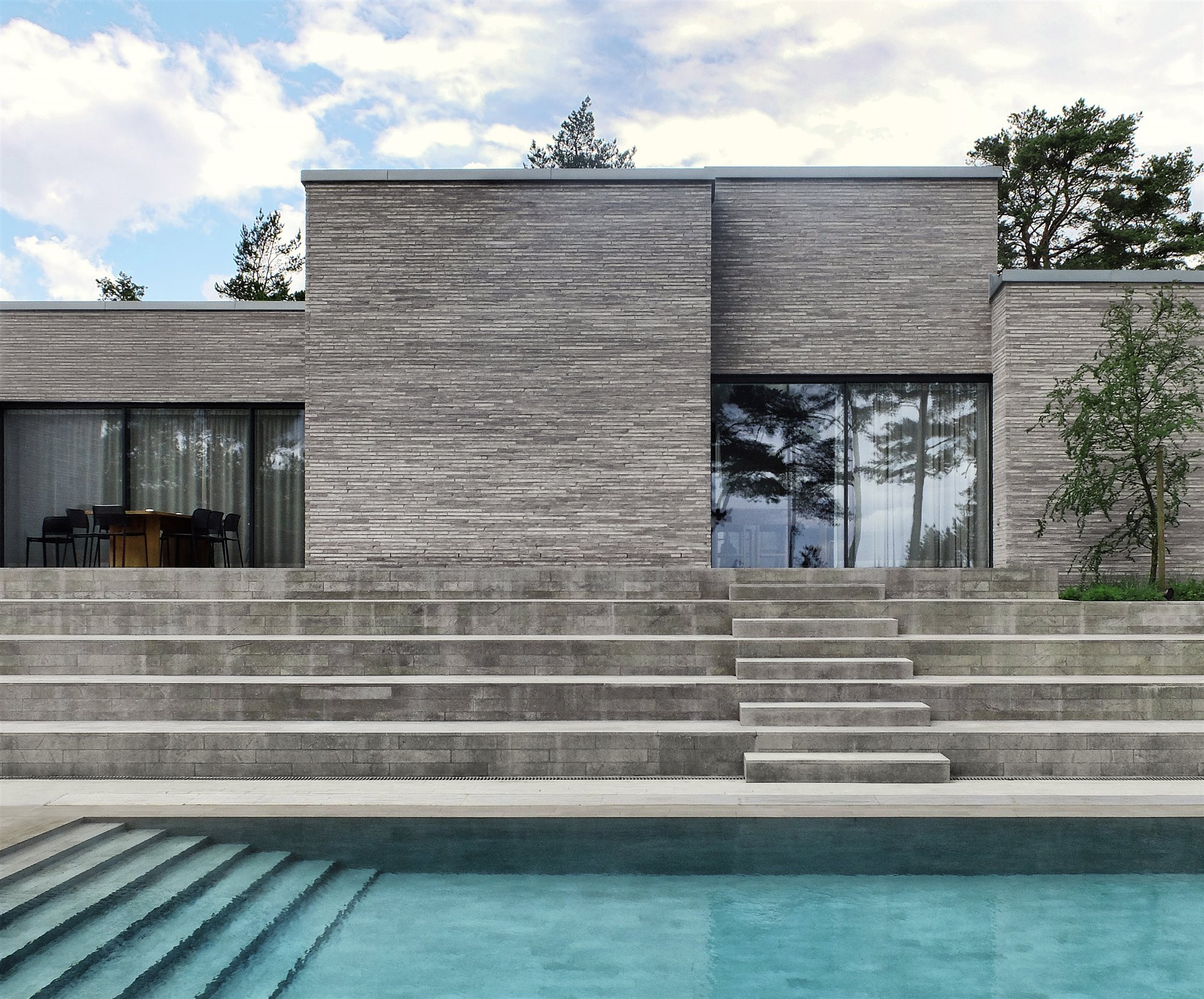 Casa moderna con fachada de piedra en mitad del bosque piscina