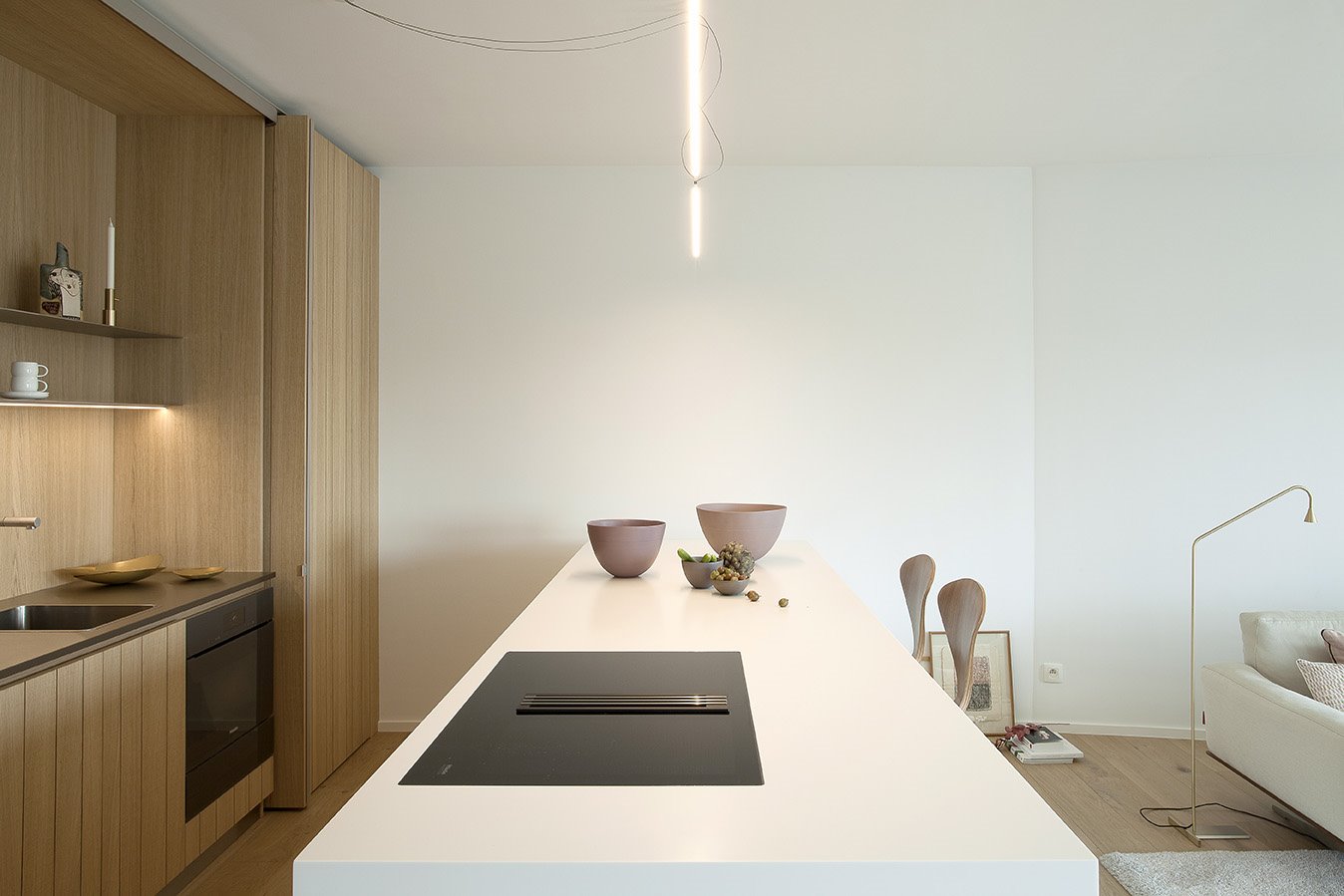 Piso con decoracion moderna en Francia con suelos y paredes de madera cocina con encimera blanca