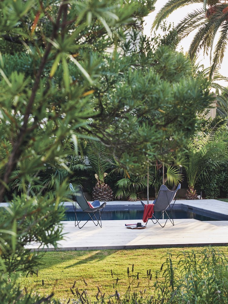Casa con butacas plegables junto a una pisicina