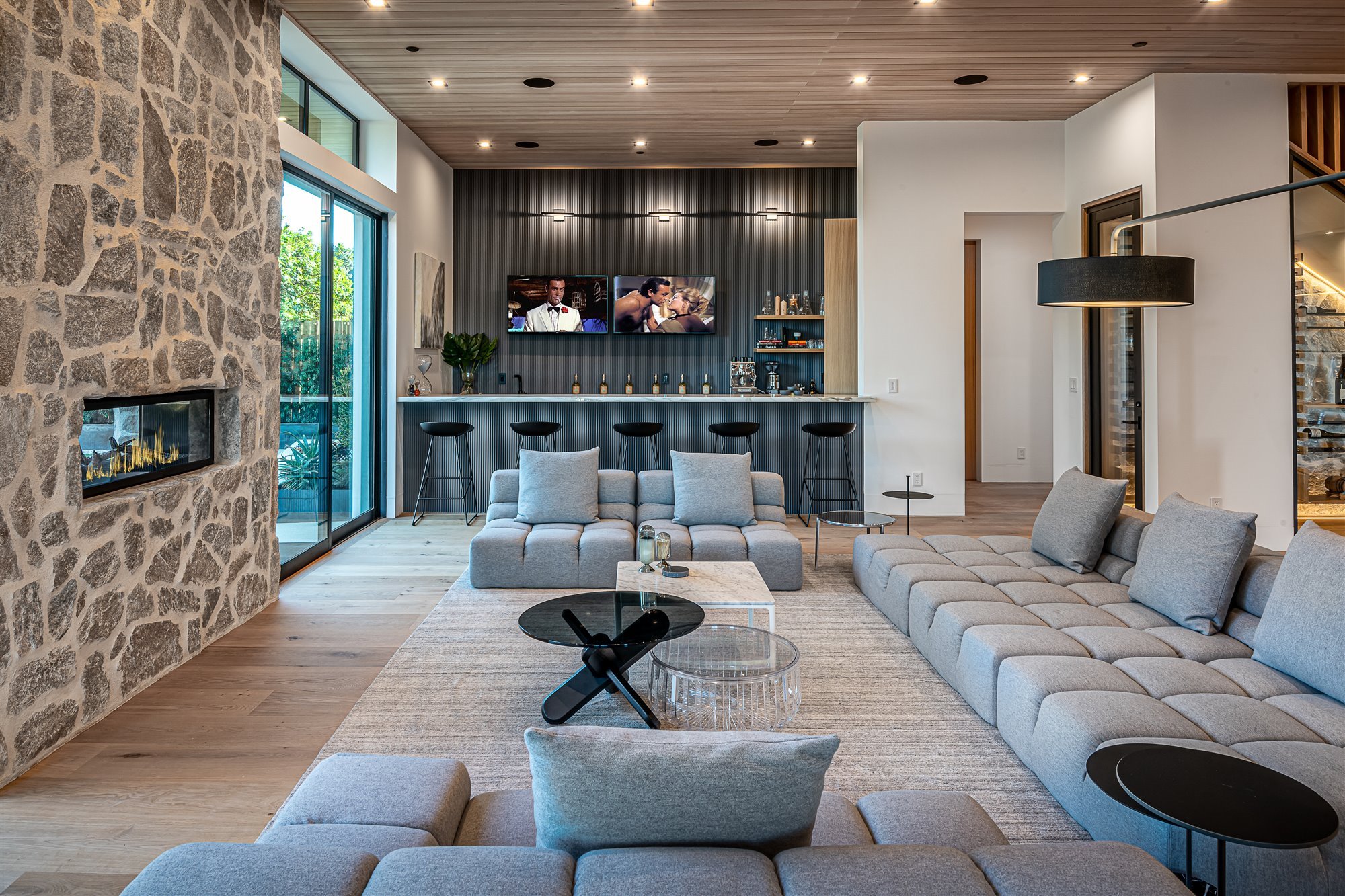 Casa moderna del actor de Modern Family Jesse Tyler Ferguson en Encino los Angeles salon con sofas grises y chimenea