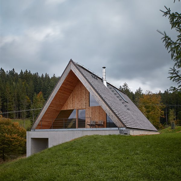 La parte superior de la fachada está revestida de madera, con terraza exterior semi-cubierta  
