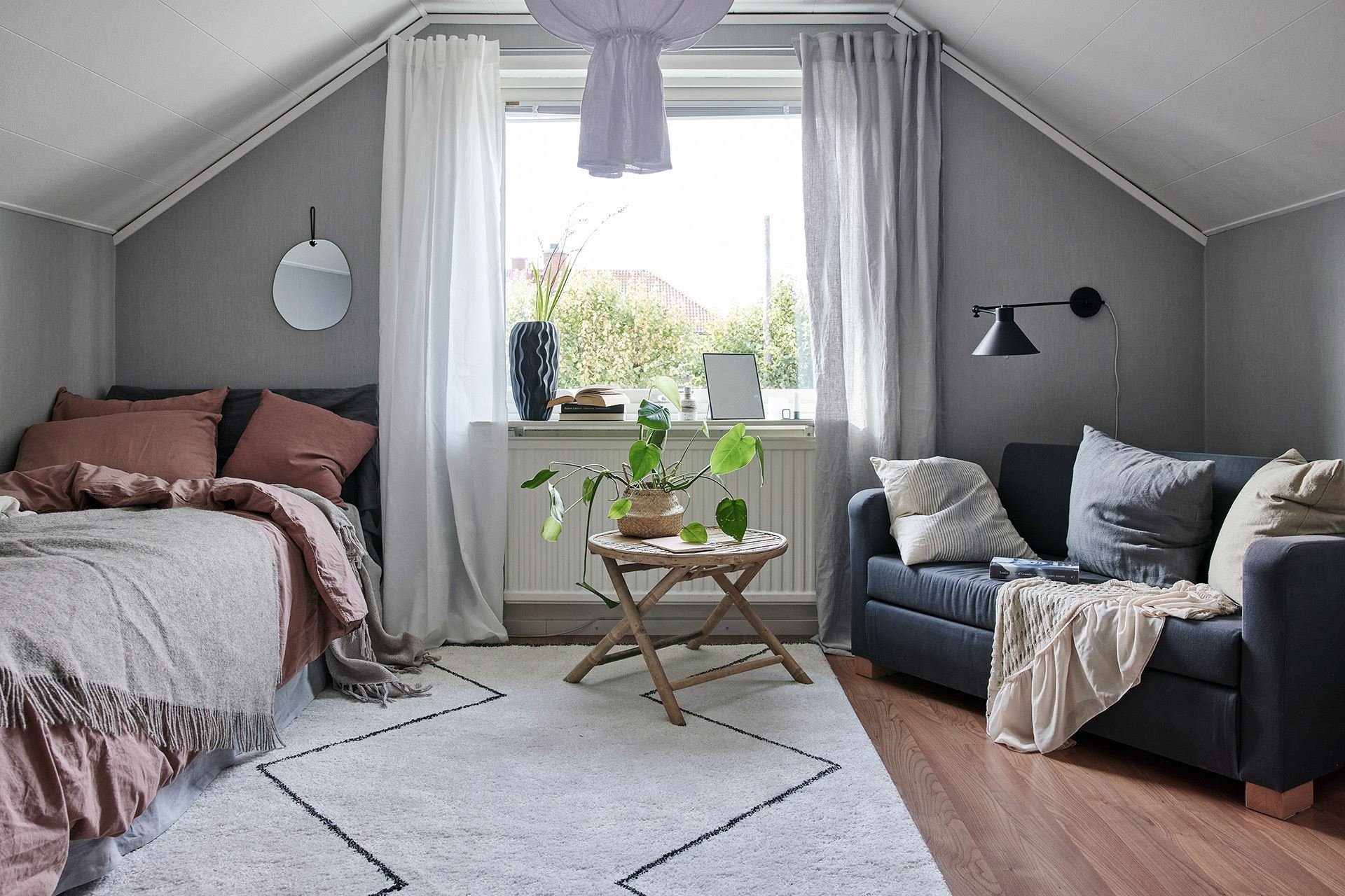 Dormitorio con sofa en buhardilla de una Casa en el campo con decoracion nordica