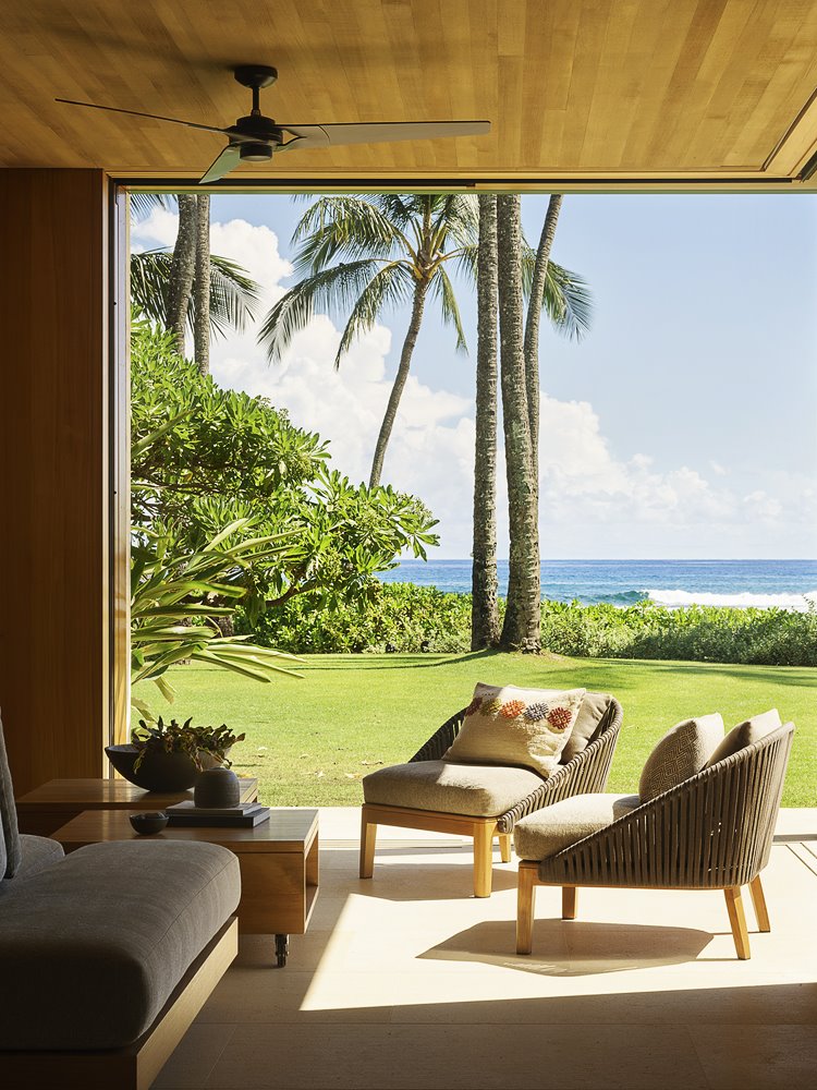 Casa moderna de hormigon y madera en Hawaii con vistas al mar butacas en el porche