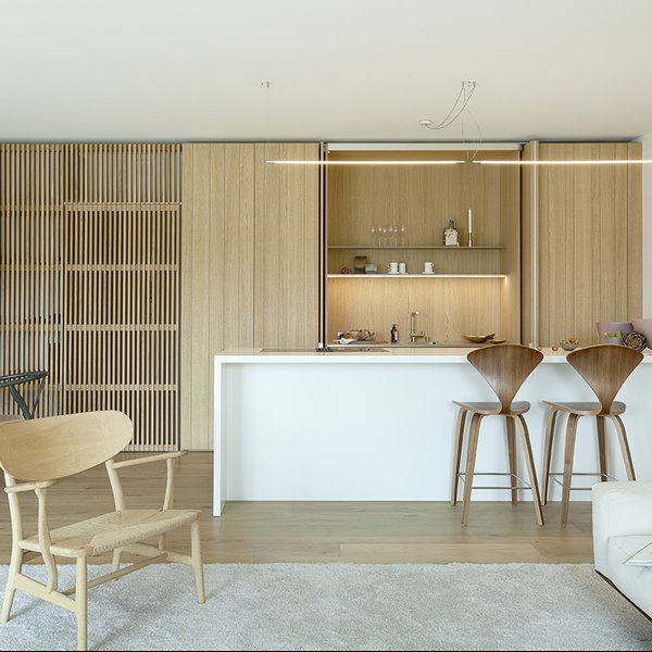 En este mini piso han usado muebles a medida para crear espacios unificados en la cocina y el salón
