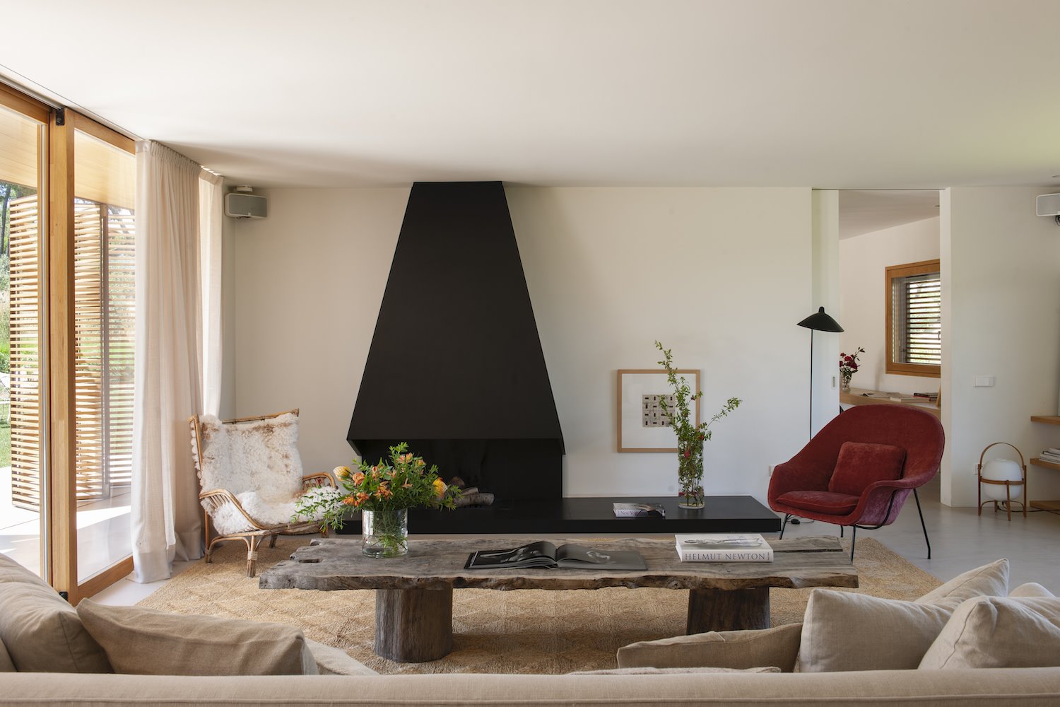 Salon con chimenea negra y mesa de madera de estilo rustico. Di adiós a  de lo que no necesitas