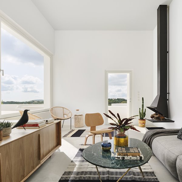 Salon con chimenea de color negro y sofa gris