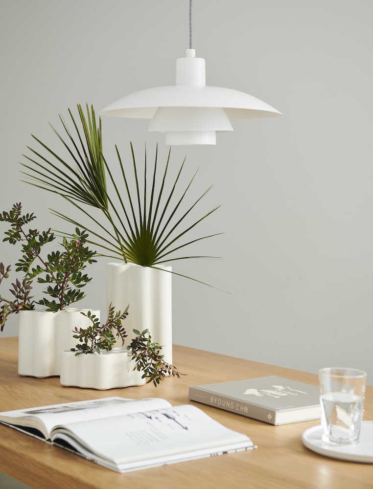 mesa con jarrones con plantas y un libro abierto. Tiempo de papel
