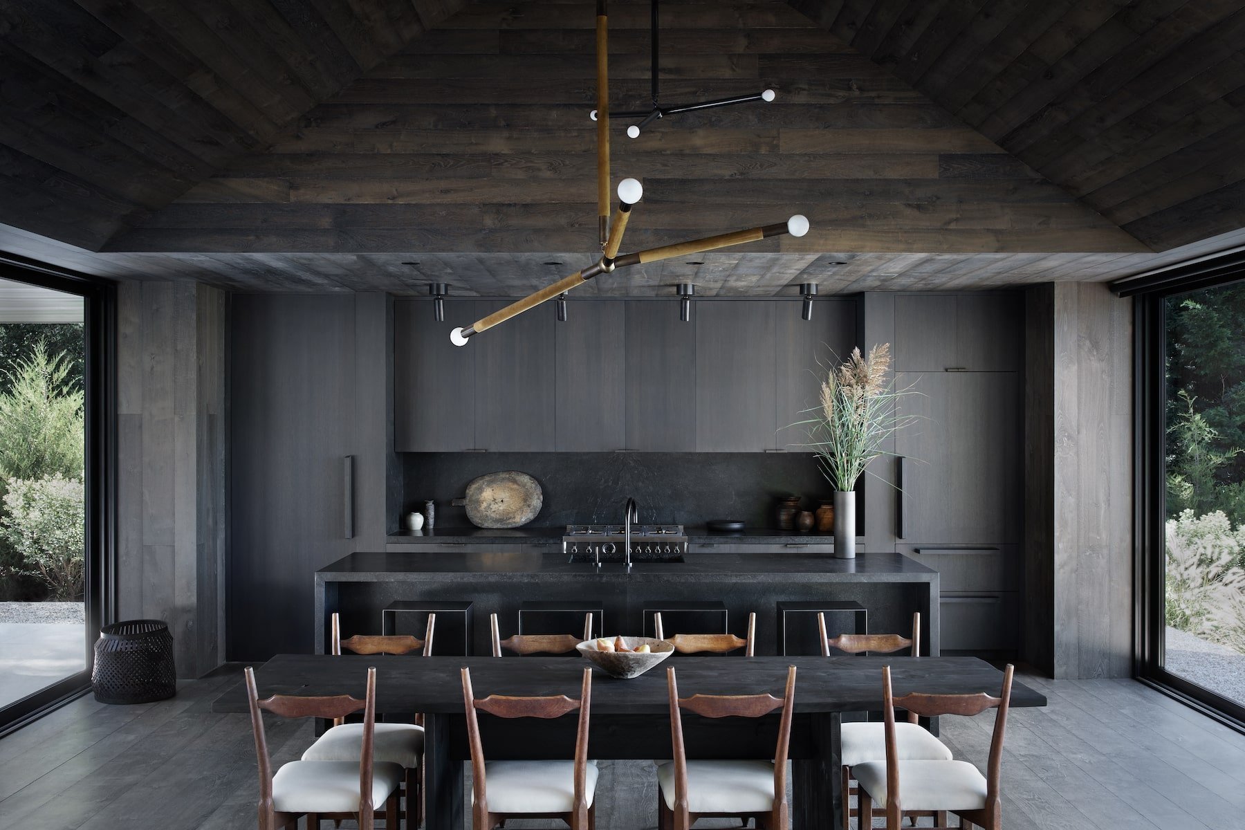 Casa en los Hamptons con fachada de madera en mitad del bosque comedor