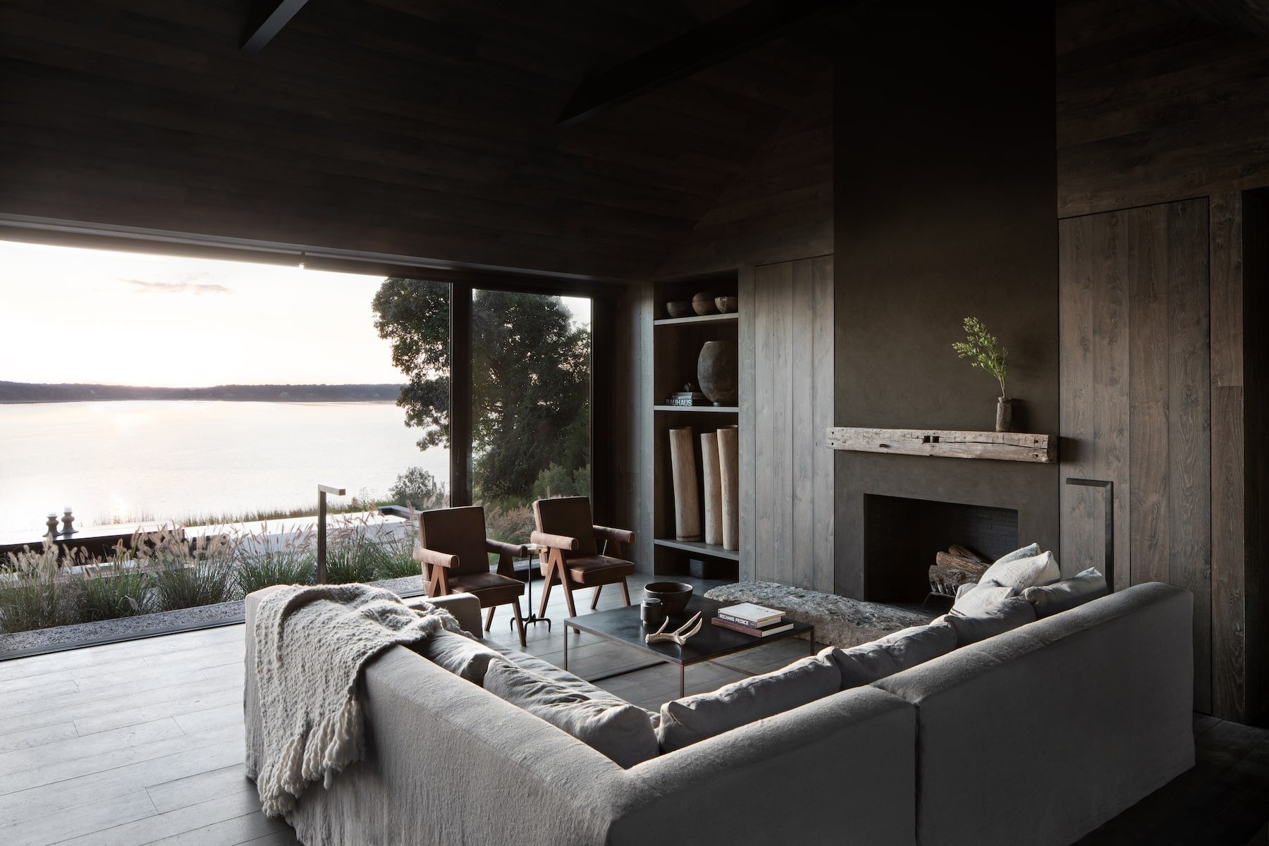 Casa en los Hamptons con fachada de madera en mitad del bosque salon abierto al lago