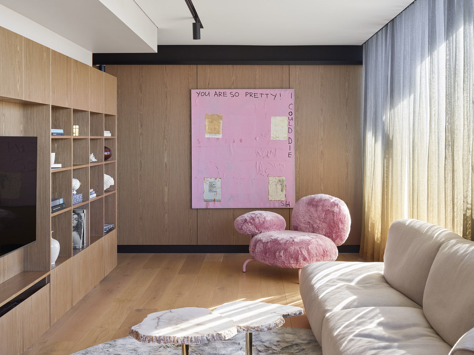 Piso moderno con interiores de madera en Brisbane Australia salon con sillon rosa