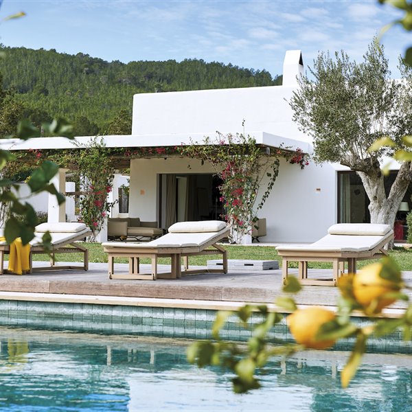 Casa con piscina con tumbonas de madera y colchoneta blanca