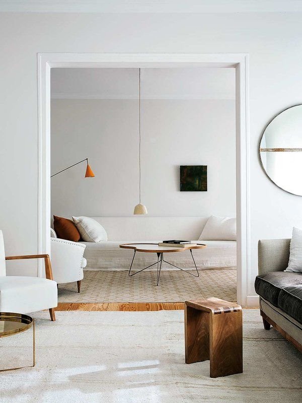 Salon minimalista con muebles en color blanco lamparas y mesilla de madera