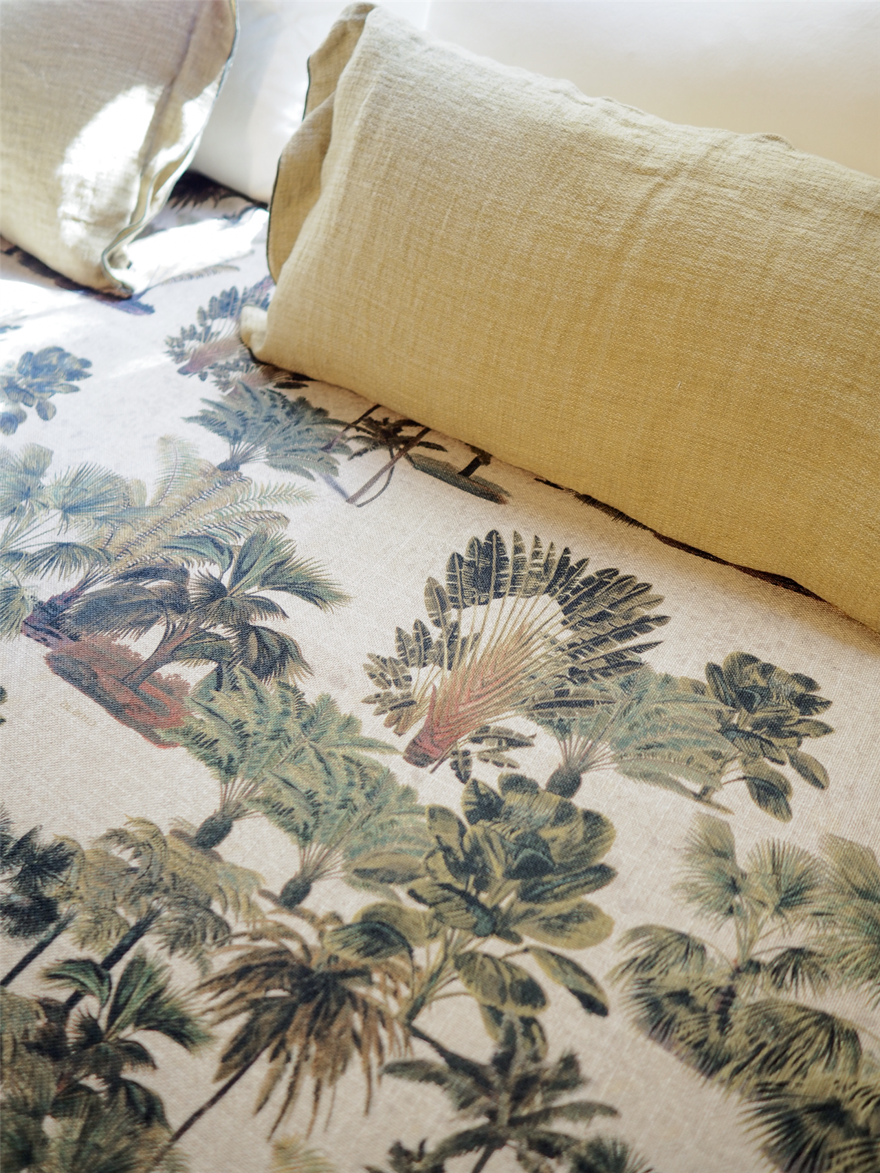 Colcha con estampado de palmeras de 'Oasis', una colección que recrea un paraje lleno de vegetación.