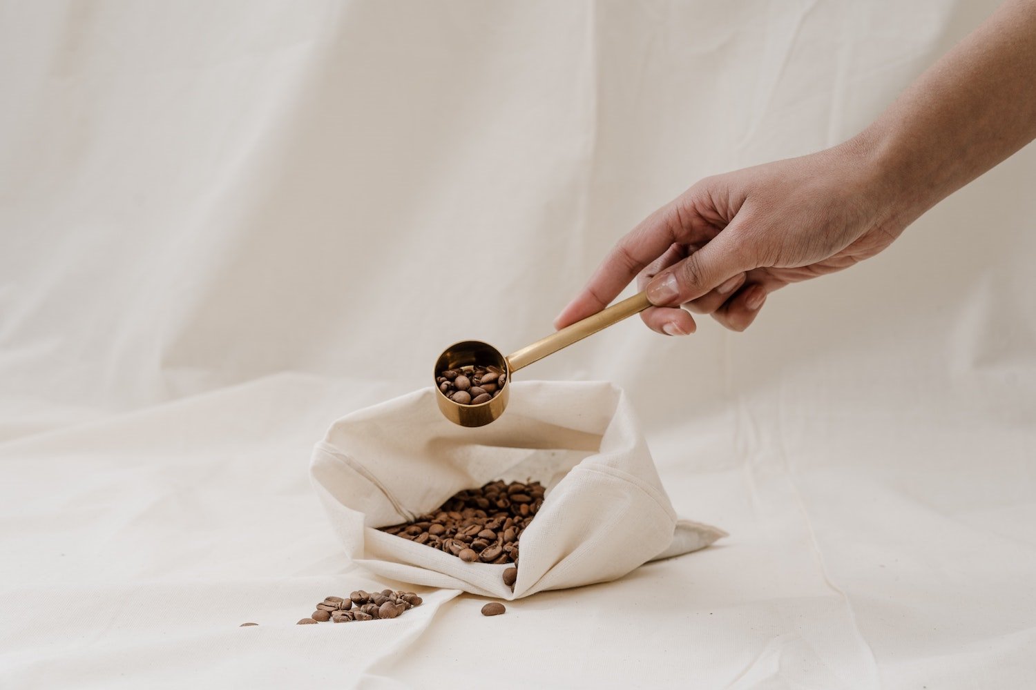 Bolsa de algodon con granos de cafe a granel. A granel