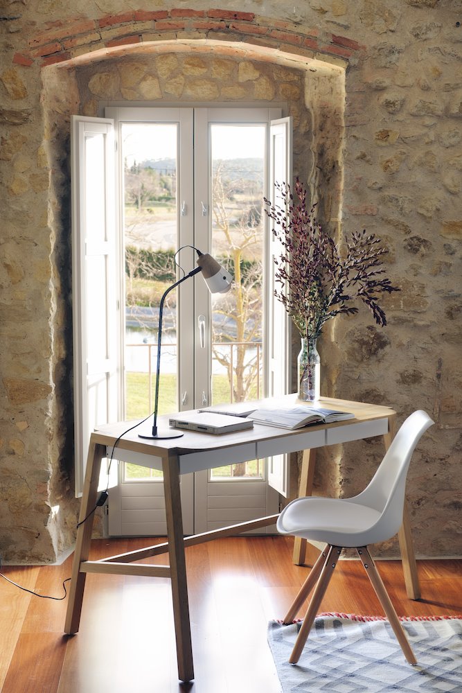 Estudio zona de trabajo en una casa de campo con muros de piedra natural Foto Pere Peris. Con armonía