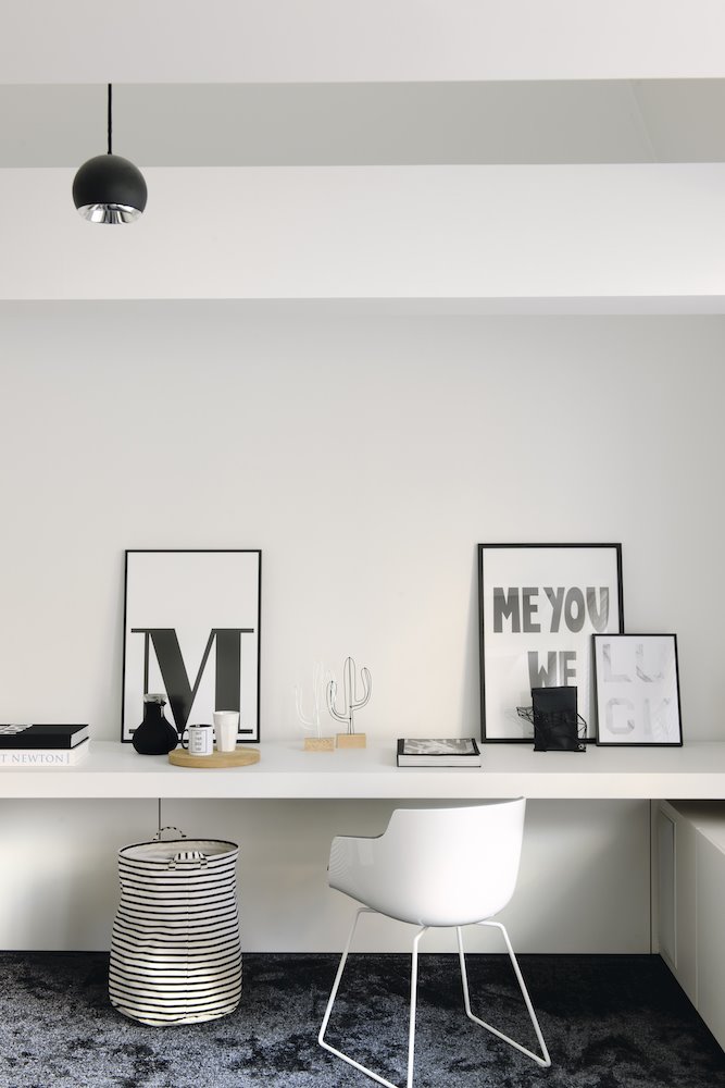 Estudio zona de trabajo en un piso con una mesa hecha a medida y silla blanca Foto Pere Peris