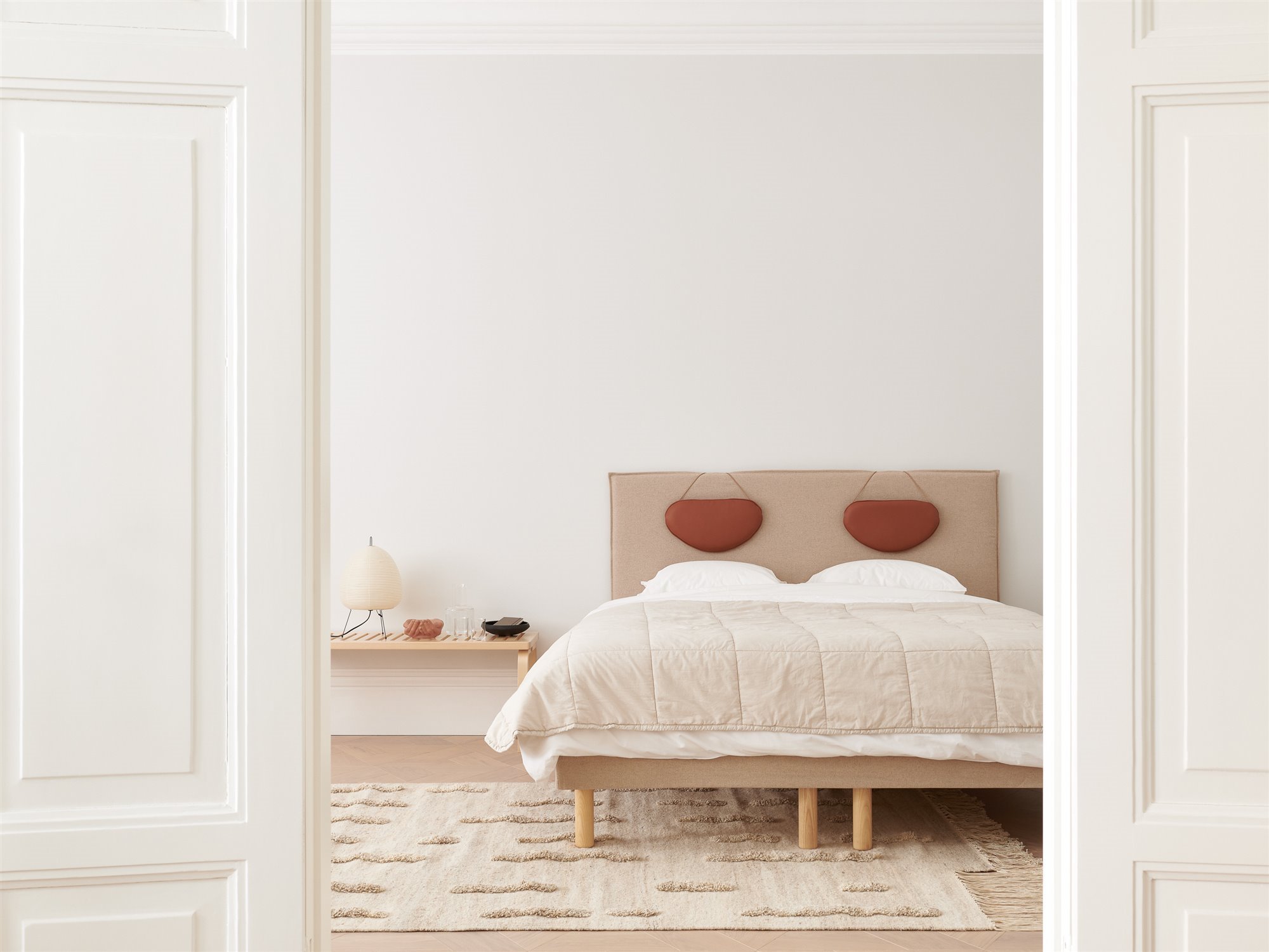 Dormitorio con decoracion nordica con cabecero de tela. Cama protagonista