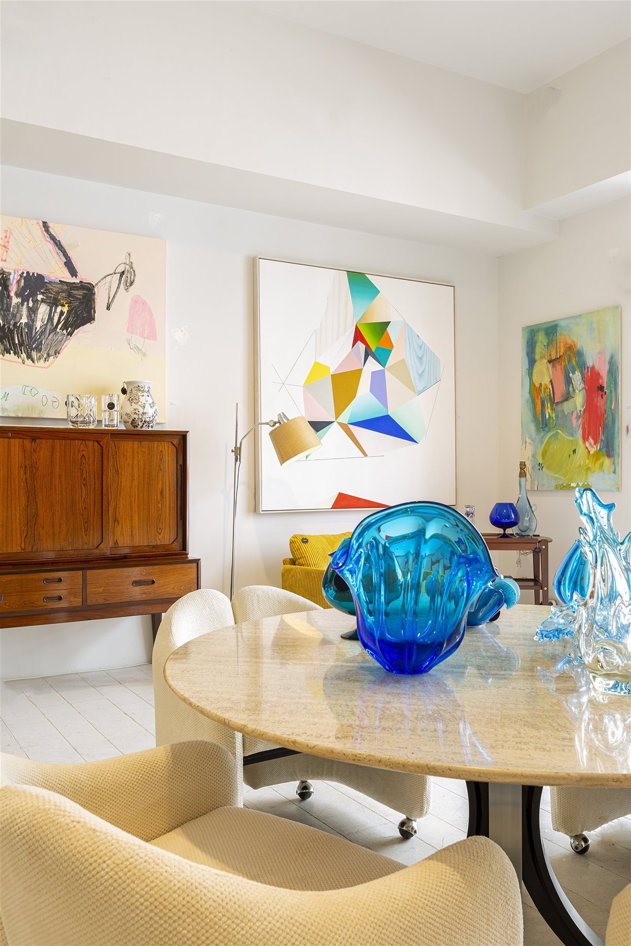 Entre las blancas paredes y el níveo suelo de la tienda, las obras de arte y las icónicas piezas decorativas aportan el color.