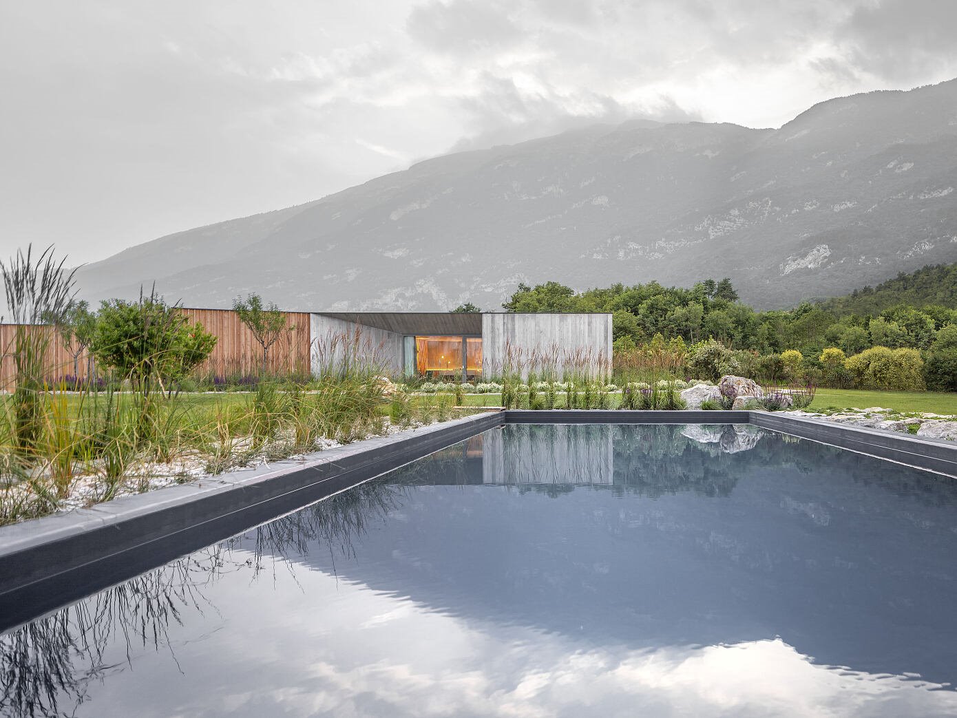 Casa de campo con fachada de madera rodeada de naturaleza con piscina