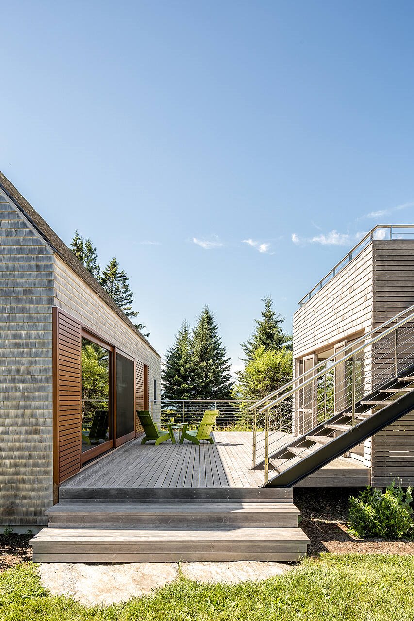 Casa de madera moderna en el campo porche con sillas de color verde