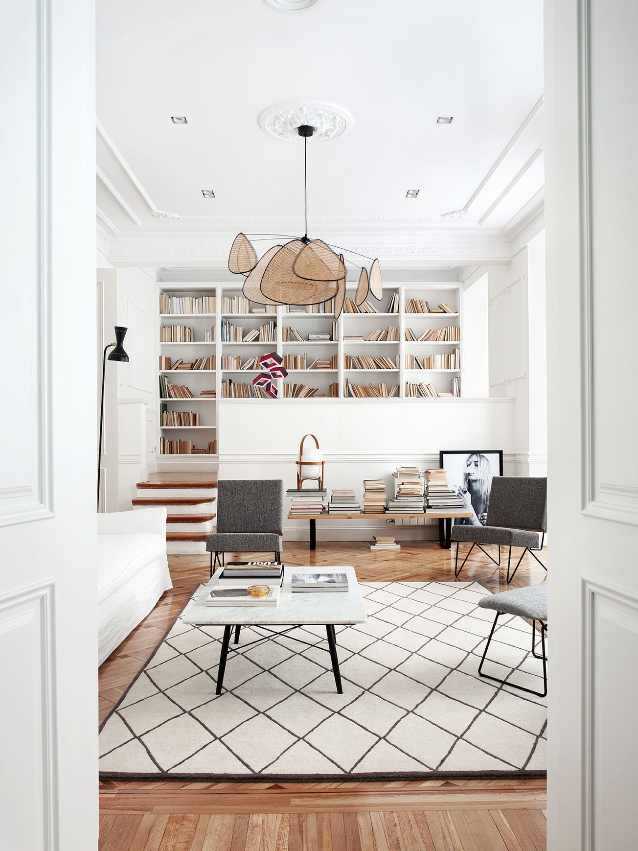 Piso moderno y reformado en Madrid con molduras y suelo de parquet salon con biblioteca