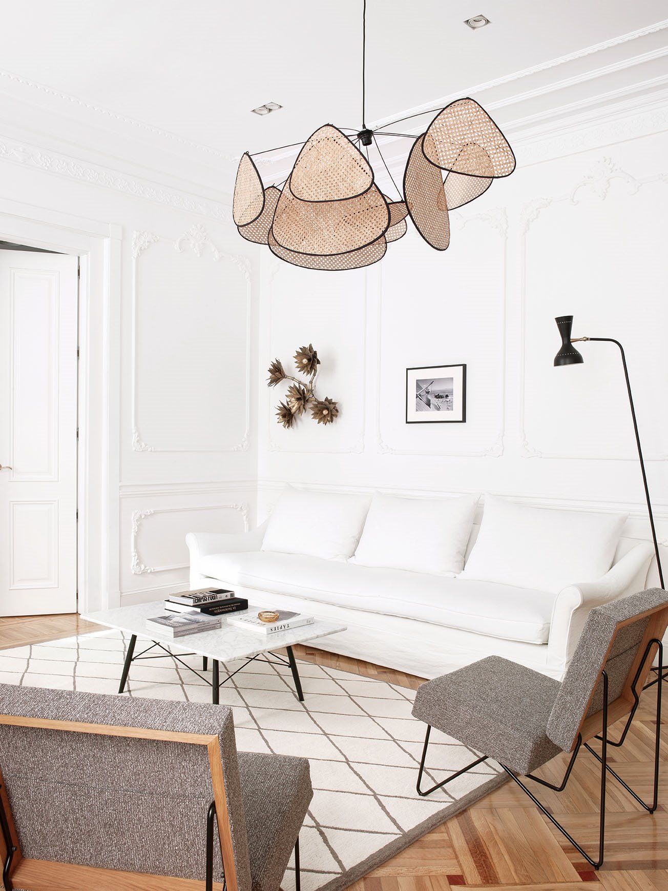 Piso moderno y reformado en Madrid con molduras y suelo de parquet salon con lampara de techo de ratan