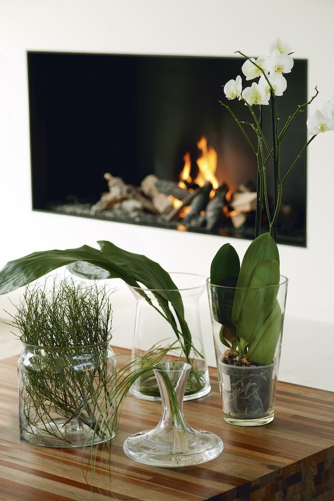 Mesa baja de madera con orquidea junto a la chimenea. 7. El truco de experta