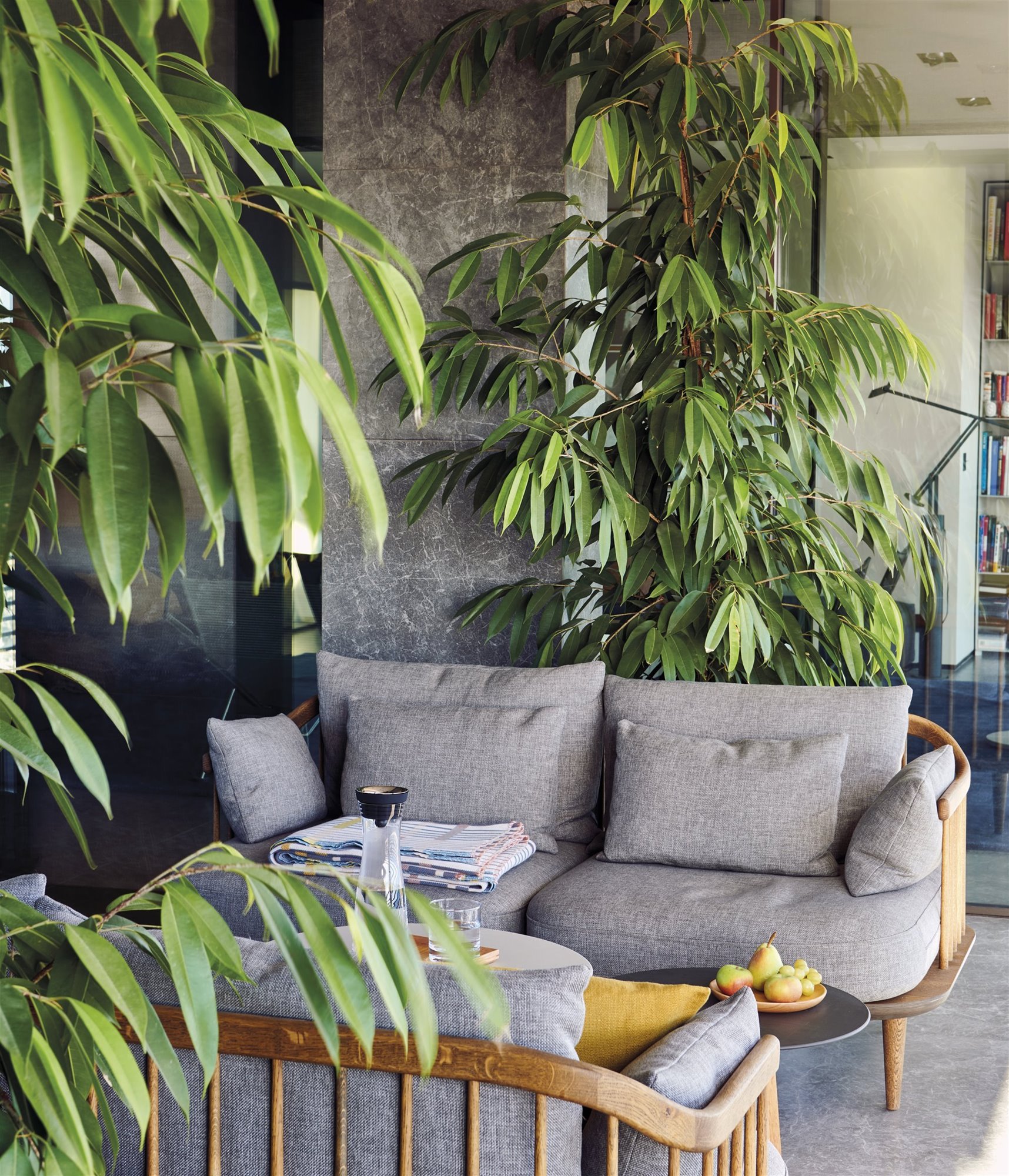 balcon con plantas y sofas de color gris